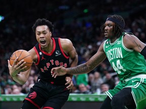 L'attaquant des Raptors de Toronto, Scottie Barnes, conduit le ballon contre le centre des Celtics de Boston, Robert Williams III.