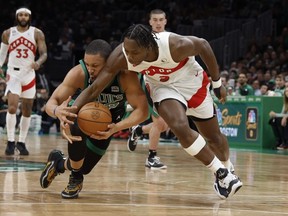 L'attaquant des Raptors OG Anunoby (3) se bat pour un ballon lâche avec l'attaquant des Celtics Grant Williams (12) au cours du deuxième quart-temps au TD Garden de Boston, le vendredi 7 avril 2023.