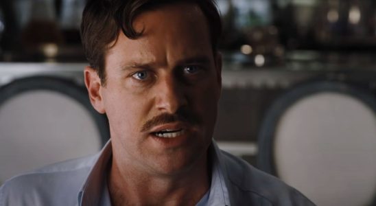 Armie Hammer sits angrily in the dining room in Death on the Nile.