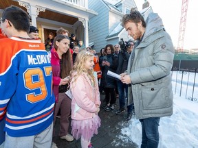 Cecily Eklund donne une carte à Connor McDavid après avoir présenté une nouvelle fourgonnette à la Kids With Cancer Society le mercredi 14 décembre 2022 à Edmonton.  Cecily a une tumeur au cerveau.