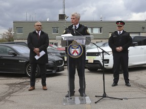 Surintendant de la police de Toronto  Ron Taverner ( au podium), flanqué du chef Myron Demkiw (R) et Del-Sgt.  Peter Wehby, de l'Unité du crime organisé (L), discute des détails du projet Stallion le 26 avril 2023. (Jack Boland, Toronto Sun)