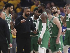 L'entraîneur-chef des Boston Celtics, Ime Udoka, au centre gauche, s'entretient avec les joueurs lors de la première moitié du match 2 de la finale NBA de basket-ball contre les Golden State Warriors à San Francisco, le dimanche 5 juin 2022.