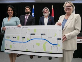 La mairesse de Montréal Valérie Plante, à gauche, avec la ministre des Transports du Québec, Chantal Rouleau, à l'extrême droite, tiennent le dernier plan de la ligne bleue du métro le vendredi 18 mars 2022 avec le ministre du Patrimoine canadien, Pablo Rodriguez, à droite, et le président de la STM, Eric Alan Calwell.  Les fonds d'infrastructure non affectés du Québec devaient être affectés au projet.