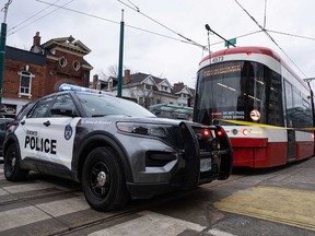 Des voitures de police entourent un tramway sur l'avenue Spadina à Toronto le 24 janvier 2023, après qu'une personne a été poignardée à plusieurs reprises dans le tramway.