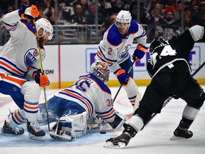 Les défenseurs des Oilers d'Edmonton Mattias Ekholm (14) et Evan Bouchard (2) aident le gardien Jack Campbell à défendre le but contre les Kings de Los Angeles.