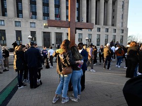 Un groupe se rassemble autour d'une croix pour prier lors d'une veillée publique pour les victimes et les survivants de la fusillade de l'école Covenant à Nashville, Tennessee, le 29 mars 2023.