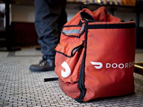 Un sac de livraison de nourriture pour DoorDash Inc. sur le sol d'un restaurant.  La moitié des Canadiens s'attendent à travailler à la demande à la retraite.