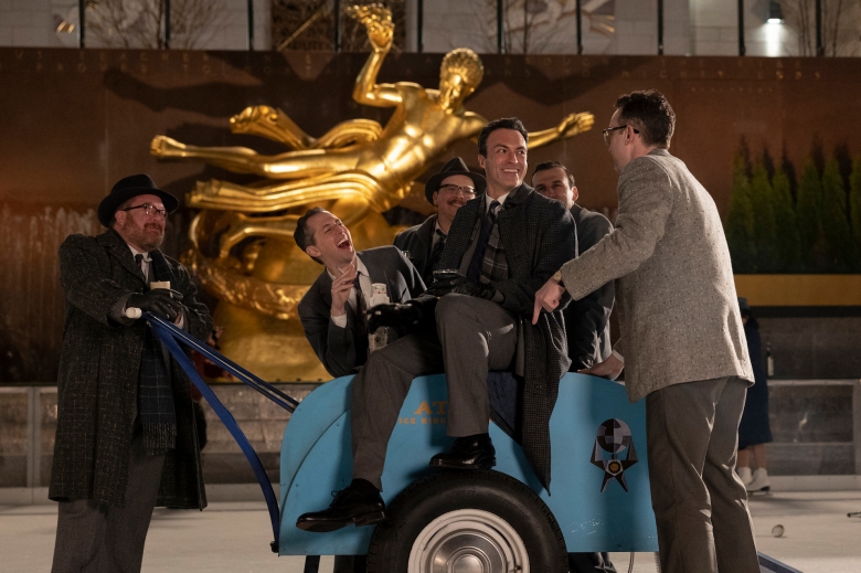 Un groupe d'hommes entourant et assis sur une patinoire des années 1960 zamboni sur la glace ;  encore de 