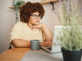 Femme travaillant sur ordinateur à la maison.