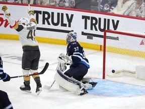 Ivan Barbashev (49 ans) des Golden Knights de Vegas célèbre après qu'un tir de son coéquipier Michael Amadio ait battu Connor Hellebuyck (37 ans) des Jets de Winnipeg lors de la deuxième période de prolongation du troisième match à Winnipeg samedi soir.