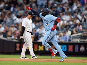 Vladimir Guerrero Jr. des Blue Jays de Toronto célèbre en faisant le tour des bases après avoir frappé un circuit de deux points lors de la première manche alors qu'Anthony Rizzo des Yankees de New York réagit au Yankee Stadium le 21 avril 2023.