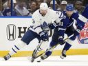 Le défenseur des Maple Leafs de Toronto Justin Holl déplace la rondelle devant le centre du Lightning de Tampa Bay Steven Stamkos lors de la première période du troisième match d'une série éliminatoire de premier tour de la Coupe Stanley de hockey de la LNH le samedi 22 avril 2023 à Tampa, en Floride (/)