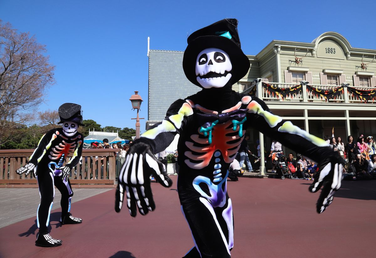 Des danseurs déguisés en squelettes colorés se produisent lors du défilé d'Halloween à Tokyo Disneyland le 22 octobre 2018