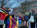 Clayton Goodwin, un ancien combattant autochtone bispirituel, tient des drapeaux arc-en-ciel lors d'une manifestation devant le siège social du conseil scolaire du district d'Ottawa-Carleton avant une réunion du conseil dans la soirée du mardi 4 avril 2023. 