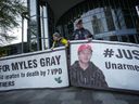 Des manifestants tiennent des bannières avec une photo de Myles Gray, décédé à la suite d'une confrontation avec plusieurs policiers en 2015, avant le début d'une enquête du coroner sur sa mort, à Burnaby, en Colombie-Britannique, le lundi 17 avril 2023. Le coroner de la Colombie-Britannique enquête sur la mort de Myles Gray a entendu le premier témoin non policier qui était sur les lieux où l'homme de 33 ans est décédé.