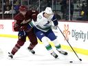 Tyler Myers des Canucks de Vancouver patine avec la rondelle contre Patrik Nemeth des Coyotes de l'Arizona lors de la première période au Mullett Arena le 16 mars 2023 à Tempe, en Arizona.