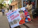 Des étudiants d'une école d'art portent un tableau représentant le roi Charles III avant son couronnement, à Mumbai le 5 mai 2023. 