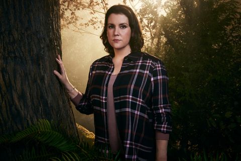 La star des gilets jaunes Melanie Lynskey, dans le personnage de Shauna, se tient dans une forêt avec sa main droite posée sur un tronc d'arbre