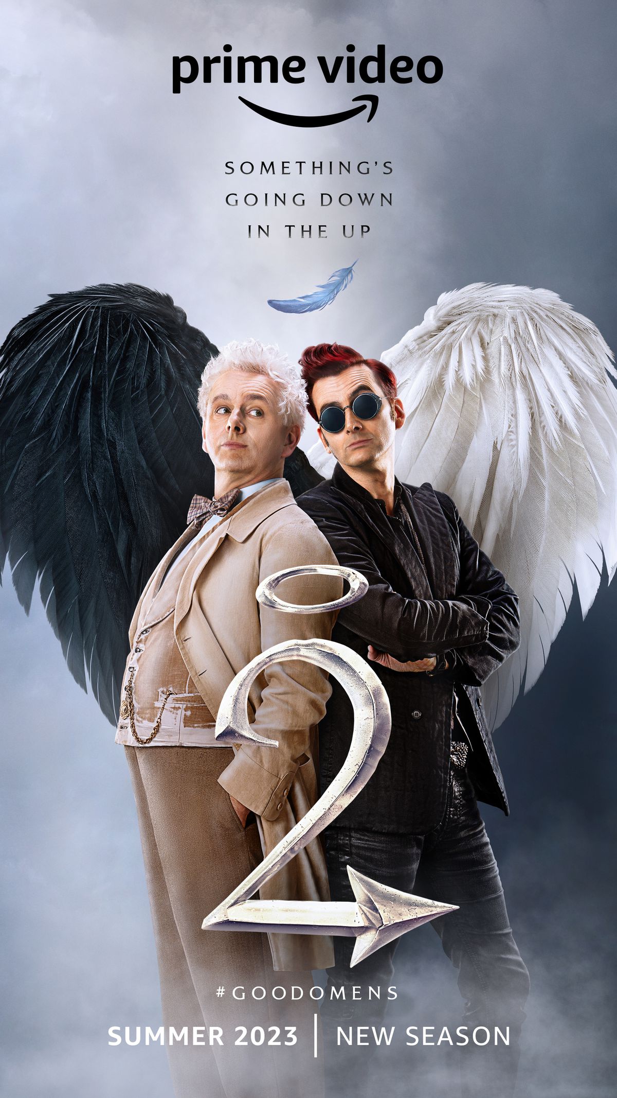 Une affiche pour Good Omens saison 2, mettant en vedette Michael Sheen comme Aziraphale et David Tennant comme Crowley, debout dos à dos avec leurs ailes formant un cœur. 