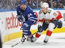 Auston Matthews des Maple Leafs (à gauche) et Gustav Forsling des Panthers poursuivent la rondelle lors du deuxième match de leur série de deuxième ronde à Toronto le 4 mai 2023.