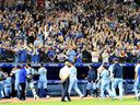 Les fans des Blue Jays applaudissent leur équipe hors du terrain après une victoire de fin de saison contre les Orioles au Rogers Centre de Toronto, le dimanche 3 octobre 2021.