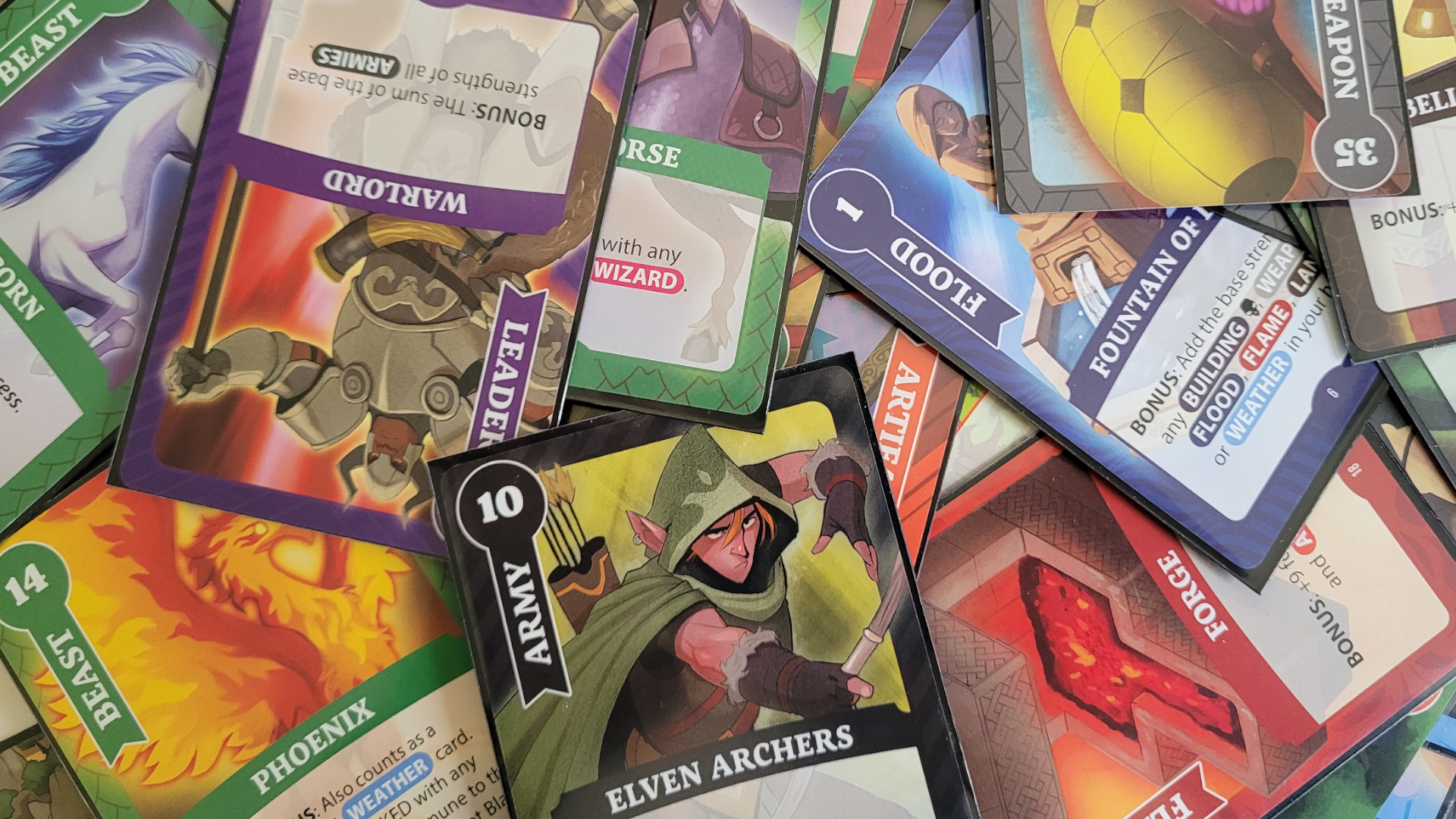 Une collection de cartes de Fantasy Realms Deluxe empilées les unes sur les autres