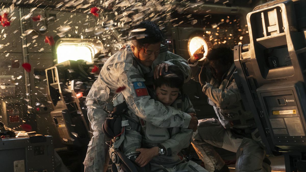 (LR) Wu Jing, Wang Zhi et Kawawa Kadichi se protégeant des éclats de verre d'une explosion dans The Wandering Earth 2.