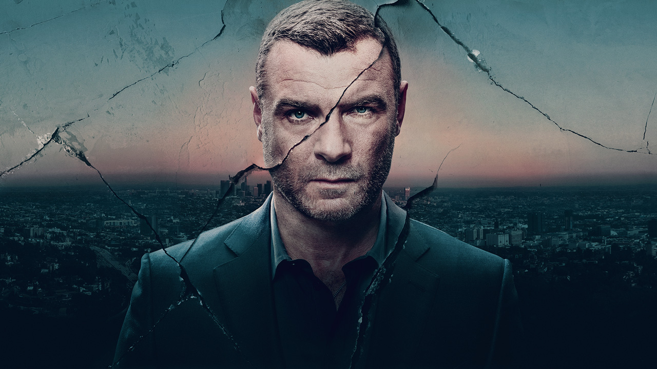 Liev Schreiber dans le rôle de Ray Donovan dans Ray Donovan montre un art déchiré et présente le paysage urbain en arrière-plan.