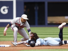 Orlando Arcia des Braves d'Atlanta marque Bo Bichette des Blue Jays de Toronto au deuxième rang au Rogers Centre le 14 mai 2023 à Toronto.