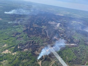 De la fumée s'élève des zones d'incendie EWF-035 près de Shining Bank, Alberta, Canada, le 13 mai 2023.