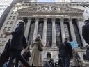 Les piétons marchent à côté de la Bourse de New York. 