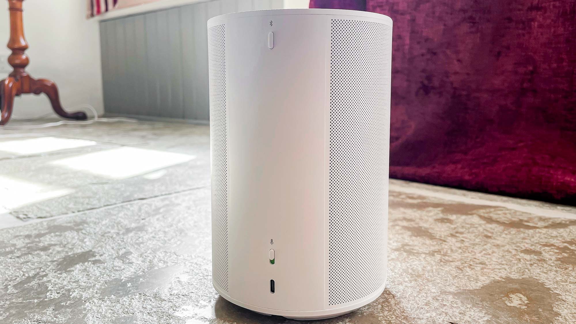 Sonos Era 100 au sol montrant l'arrière du haut-parleur et le port de connectivité