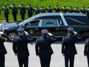 Des membres de la Police provinciale de l'Ontario saluent le véhicule transportant le sergent de la Police provinciale de l'Ontario.  Eric Mueller quitte le terrain du Centre Canadian Tire à la suite de funérailles à Ottawa, le jeudi 18 mai 2023. Sgt.  Mueller a été tué dans l'exercice de ses fonctions alors qu'il répondait à un appel le 11 mai dans le village de Bourget, en Ontario.