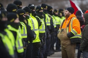 Un mur de policiers affronte des manifestants anti-COVID 19 le 12 février 2022 sur Huron Church Road pendant le blocus du pont Ambassador.  (DAX MELMER/Windsor Star)