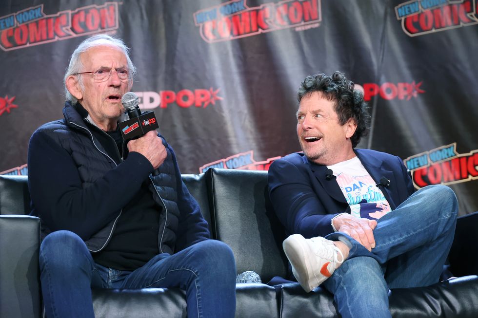 christopher lloyd et michael j fox s'assoient ensemble sur un canapé alors qu'ils parlent lors d'un panel de la convention