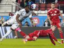 L'attaquant du Toronto FC Ayo Akinola (20) dirige le ballon alors que l'attaquant des New York Red Bulls Cameron Harper (17) défend et le défenseur Dylan Nealis (12) regarde pendant la deuxième mi-temps de l'action de soccer MLS à Toronto le 17 mai 2023.