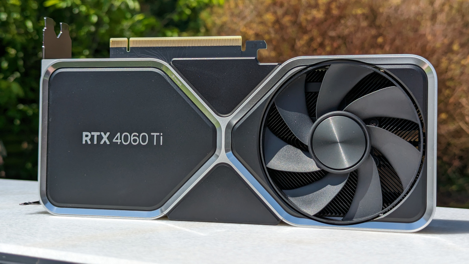 Test de la Nvidia GeForce RTX 4060 Ti 8 Go : la carte graphique sur une surface blanche, sur fond de nature