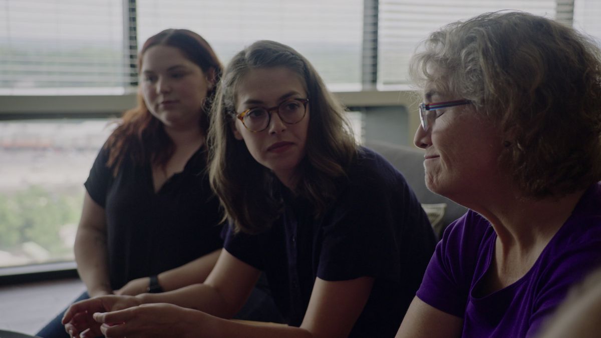 (De gauche à droite) Trois femmes (Emma Mannion, Rae deLeon et Lisa Rappa-Mannion) assises côte à côte sur un canapé dans Victim/Suspect.