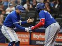 Le voltigeur droit des Blue Jays de Toronto George Springer, à gauche, célèbre avec le joueur de premier but Vladimir Guerrero Jr. après avoir réussi un coup de circuit lors de la troisième manche contre les Rays de Tampa Bay au Tropicana Field de Saint-Pétersbourg, en Floride, le 23 mai 2023.