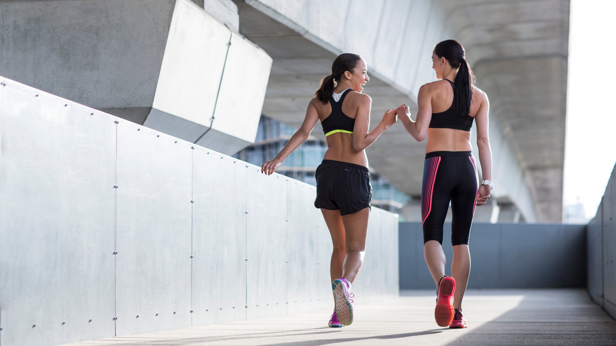 une photo de deux femmes marchant dans des soutiens-gorge de sport