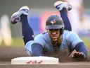 Le voltigeur des Blue Jays de Toronto George Springer glisse en toute sécurité dans la troisième base contre les Twins du Minnesota lors de la première manche au Target Field.  