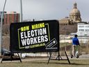 L'Assemblée législative de l'Alberta est visible derrière un panneau, dans la vallée fluviale d'Edmonton, annonçant l'embauche de travailleurs électoraux avant les prochaines élections provinciales en Alberta, le mercredi 26 avril 2023.