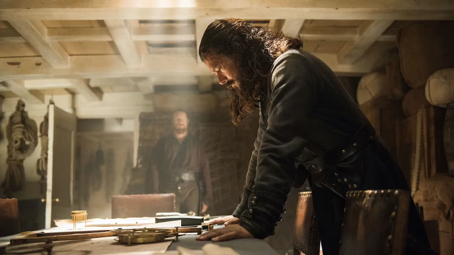 Luke Arnold dans le rôle de Long John Silver dans Black Sails, regardant une carte