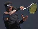 Mikael Ymer de Suède joue un retour de coup droit à Yoshihito Nishioka du Japon lors de leur match de premier tour à l'Open d'Australie.