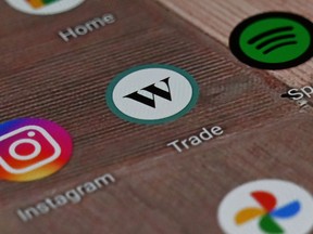 Une application Wealthsimple Trade sur un smartphone.  Les fintechs canadiennes n'ont pas été aussi durement touchées que les banques régionales aux États-Unis.