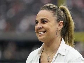 L'entraîneur des Las Vegas Aces, Becky Hammon, se tient sur le terrain avant un match de football de la NFL entre les Denver Broncos et les Las Vegas Raiders, le dimanche 2 octobre 2022 à Las Vegas.