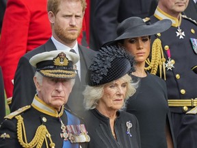 Le roi Charles III, en bas à gauche, Camilla, la reine consort, Meghan, la duchesse de Sussex et le prince Harry regardent le cercueil de la reine Elizabeth II placé dans le corbillard après les funérailles d'État à l'abbaye de Westminster, dans le centre de Londres, le lundi 19 septembre. , 2022.