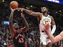 L'attaquant des Raptors de Toronto Pascal Siakam (43 ans) tire le ballon alors que l'attaquant des Indiana Pacers Oshae Brissett (12 ans) défend en seconde période à la Scotiabank Arena.