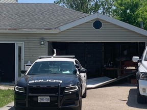 Une porte de garage cassée jonche l'allée d'une maison de Stoney Creek le lundi 29 mai 2023, où deux personnes ont été tuées et leur meurtrier présumé a été abattu par la police au cours du week-end.