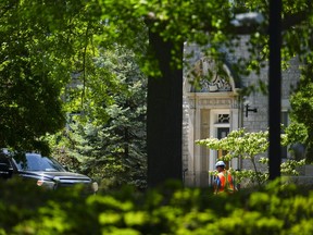 Un travailleur de la construction passe devant l'entrée principale du 24, promenade Sussex à Ottawa le lundi 29 mai 2023.